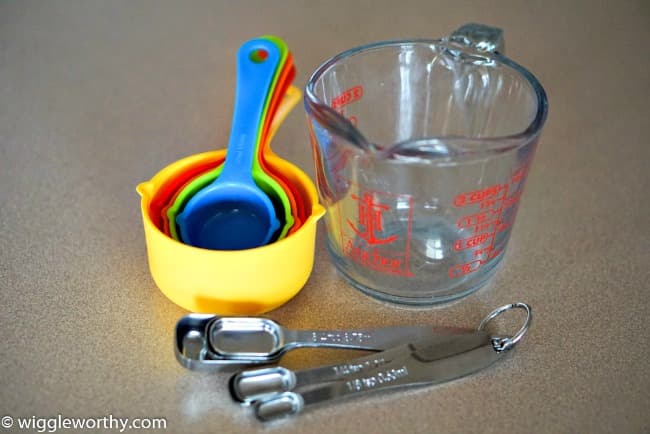 Measuring cups, jug and oblong measuring spoons for dog treat recipe use