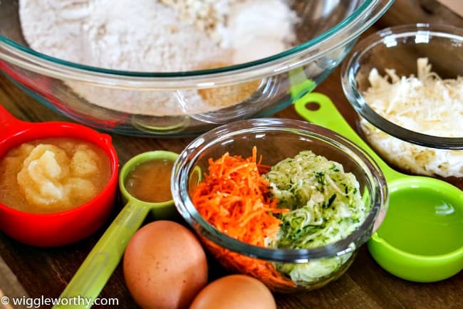 Ingredients used to make carrot zucchini pupcakes arranged on wooden tray Ingredients used to make carrot zucchini pupcakes arranged on wooden tray