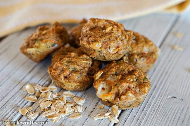 Carrot Zucchini pupcakes on whitewashed board with rolled oats sprinkled beside them Carrot Zucchini pupcakes on whitewashed board with rolled oats sprinkled beside them
