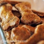 Bone shaped peanut butter and banana dog treats in glass dish